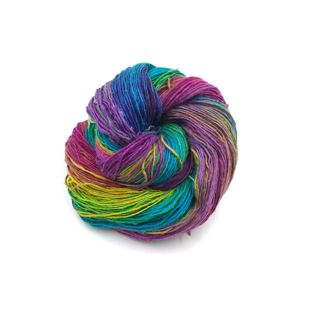Lace weight silk yarn in color way Watercolors  (multicolored) in front of white background.