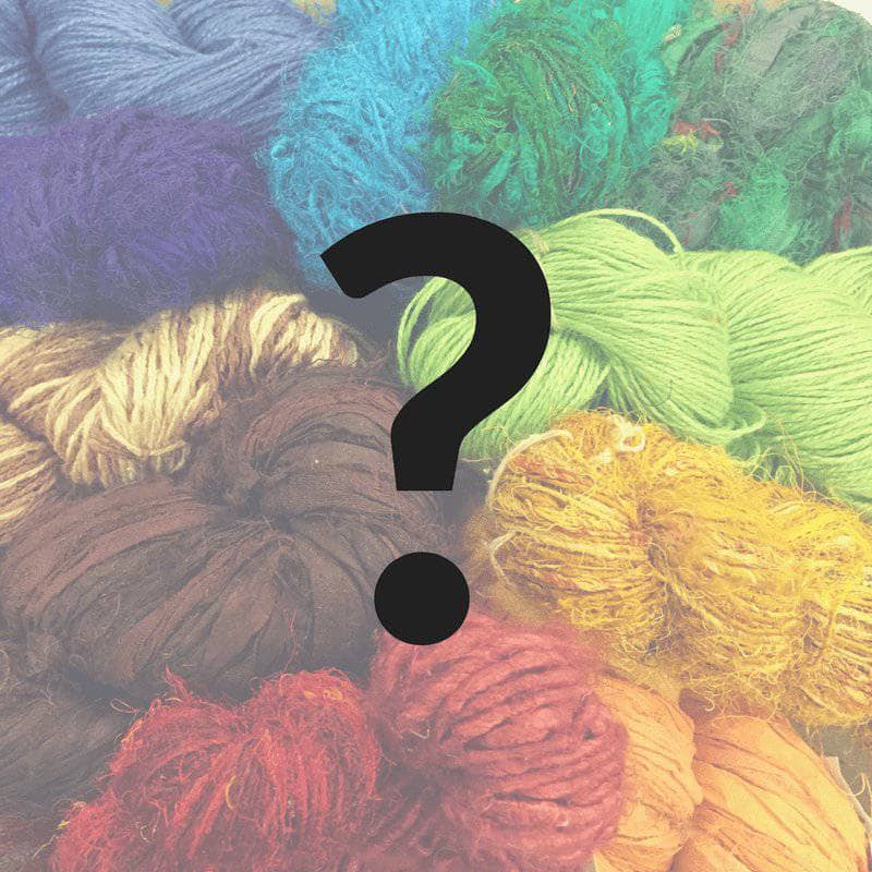 question mark with yarn cakes in the background