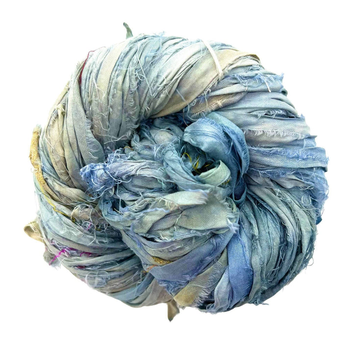 Tightly wrapped ball of shredded, frayed fabric strips in blue, green, and beige.
