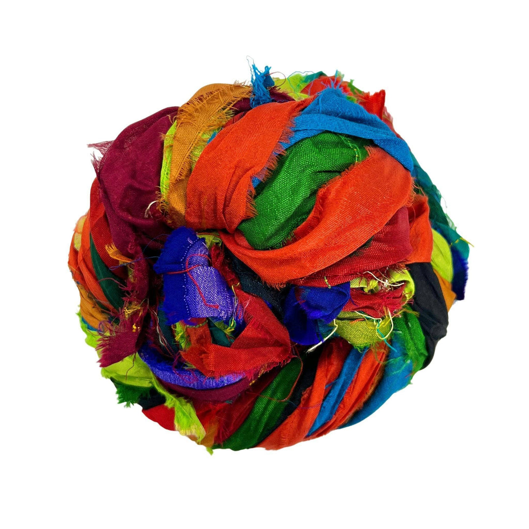 A colorful ball made from intertwined strips of vibrant fabric.