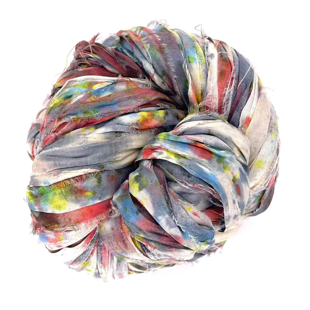 A large ball of frayed fabric strips in blue, red, yellow, and green hues.