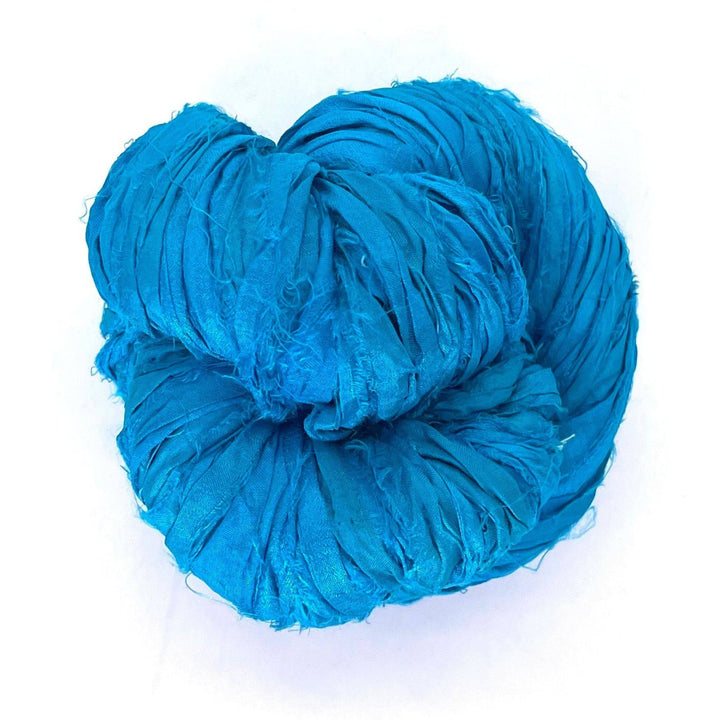 A folded bundle of bright blue fabric strips in a circular shape on a white background.