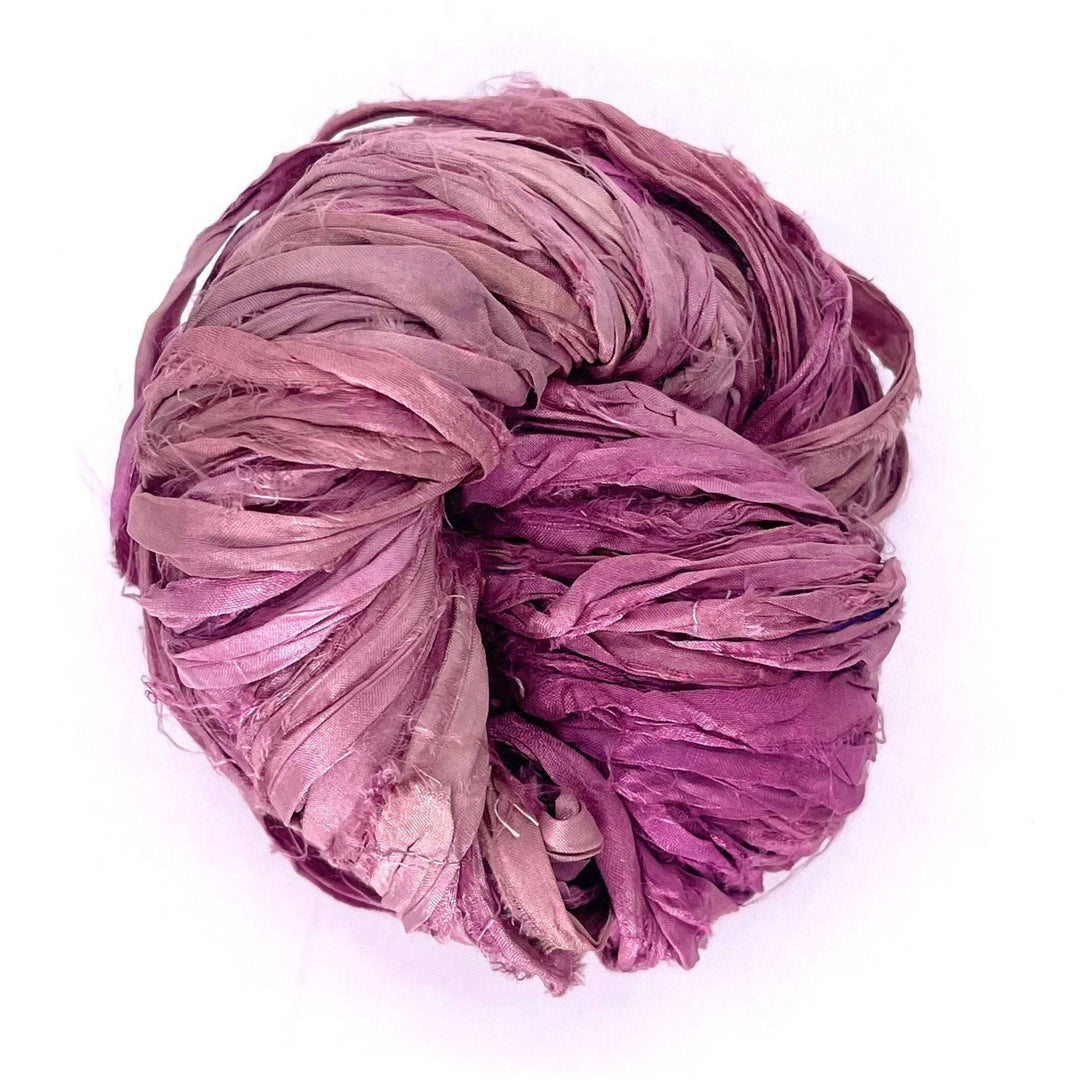 A tightly coiled ball of pink and purple fabric strips.