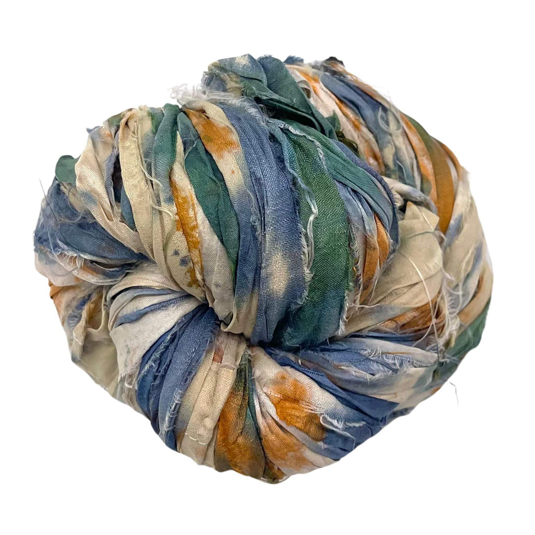 Ball of crumpled fabric strips in blue, green, beige, and brown shades.
