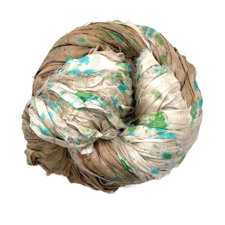 Tight ball of brown, white, and green tie-dyed fabric against a plain white background.