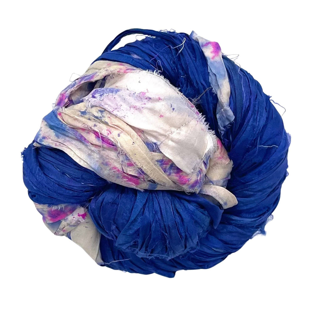 A large ball of tangled blue, white, and purple fabric strips.