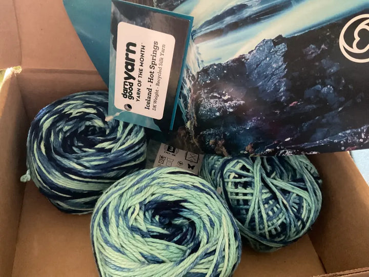 A box of Darn Good Yarn’s Iceland Hot Springs yarn in beautiful blue and green shades